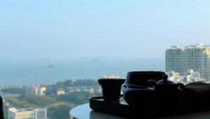 a table with cups on it with a view of a city at Hotel Nikko Xiamen in Xiamen