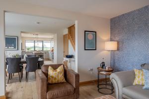 a living room with a couch and a dining room at Ellesmere Barn in Bedale