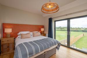 a bedroom with a bed and a large window at Ellesmere Barn in Bedale
