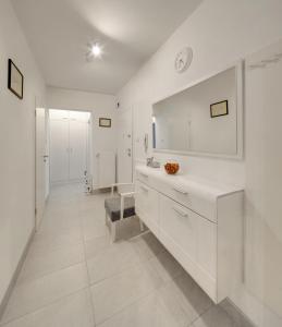 a white bathroom with a sink and a mirror at Apartment Osijek-Tvrda in Osijek