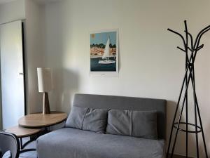 a living room with a gray couch and a table at Gîte de Broy in Vicq-dʼAuribat