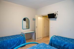 a room with two blue beds and a mirror at Hotel Centrale in Pineto +84 photos