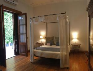 1 dormitorio con 1 cama con dosel y 2 lámparas en Cruce´s Hotel Boutique en Buenos Aires