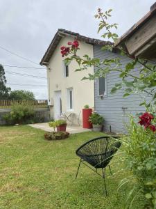 a chair in a yard next to a house at Gîte de Broy in Vicq-dʼAuribat