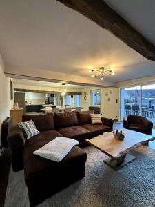 a living room with a brown couch and a table at La Longère du Menuisier : Spa-Châteaux-Beauval in Romorantin +23 photos