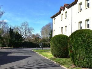 a white house with bushes next to a street at Hôtel Ibis Nevers in Nevers