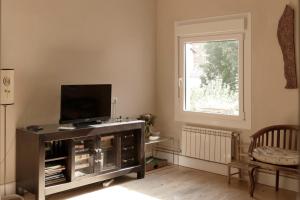 a living room with a tv and a window at Hostal Canigó in El Pont de Suert