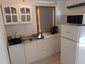 a kitchen with white cabinets and a refrigerator at Anna Ház in Balatonfenyves +4 photos