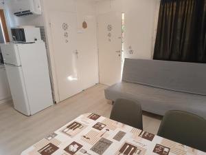a room with a refrigerator and a table and chairs at Anna Ház in Balatonfenyves
