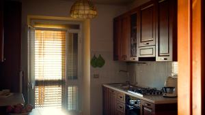 a kitchen with a window and a stove top oven at Camera Alcova in giardino in Cellino Attanasio +8 photos