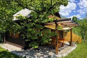 a wooden cabin with a bench next to a tree at Edi Cottage in Bovec