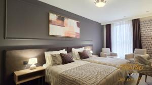 a large bedroom with two beds and a chair at Hotel Siesta in Užice