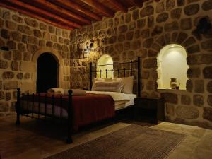 a bedroom with a bed in a stone wall at Mara Loya Konağı in Mardin