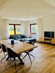 a living room with a table and a couch at Landhaus Mira in Witzenhausen