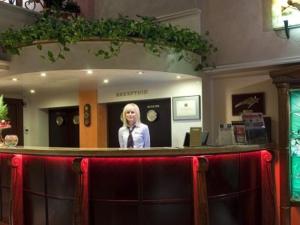 a woman standing behind a bar in a room at Capitol Hotel in Varna City