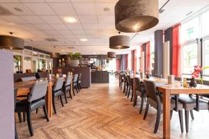 a dining room with wooden tables and chairs at Hotel Spelderholt in Beekbergen