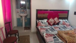 a bedroom with a bed with a pink headboard and a sink at VAIBHAV VILAs in Gangolihāt +3 photos