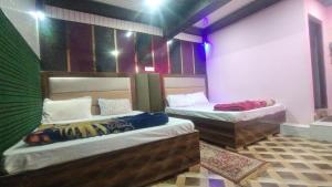 two beds in a room with colorful walls at VAIBHAV VILAs in Gangolihāt