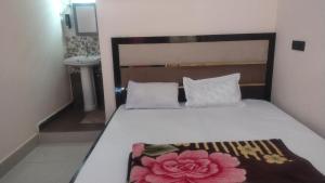 a bedroom with a bed with a flower blanket on it at VAIBHAV VILAs in Gangolihāt