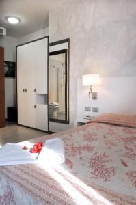 a bedroom with a large bed with a flower on it at Hotel Venezia in Caorle