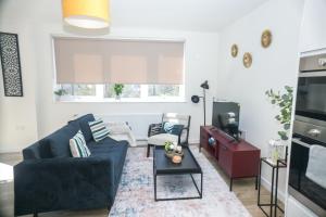 a living room with a blue couch and a table at Little Haven Thames view Free Parking Closer to Heathrow in Staines