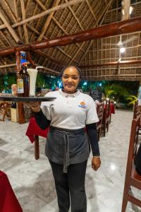 a woman is holding a tray of food at Malika Nungwi Hotel in Nungwi +246 photos