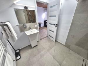 a white bathroom with a sink and a shower at Central Stay Suites Targu Mures in Târgu-Mureş +10 photos