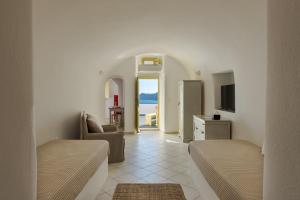 a living room with two beds and a view of the ocean at Just Blue in Oia