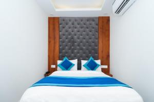 a bedroom with a large bed with blue pillows at Mukul inn in Gurgaon