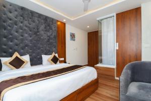 a bedroom with a large bed and a chair at Mukul inn in Gurgaon