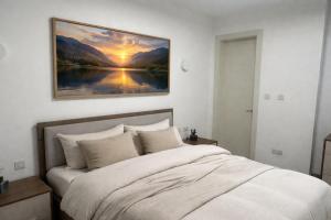 a bedroom with a bed with a painting on the wall at Ta' Cenc Residence Block C, Apt 4 in Sannat
