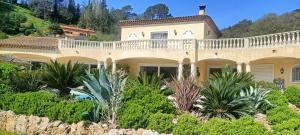 a large house with a balcony on a hill at Les murmures du jardin in Pégomas