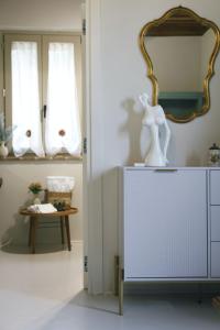 a room with a mirror and a white dresser at Casale21 in Castiglion Fiorentino