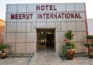 a hotel with a sign on the front of a building at Hotel Meerut International in Meerut