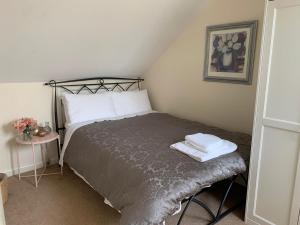 a small bedroom with a bed with two towels on it at The Flat in Tintinhull