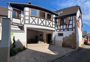 a white and black house with a garage at Chez Netty Gite avec sauna à Beblenheim in Beblenheim