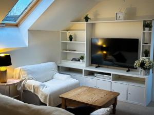 a living room with a tv and a couch at The Flat in Tintinhull