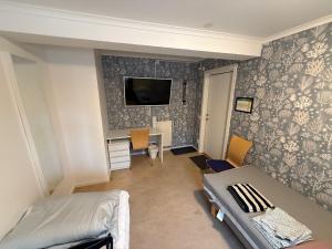 a bedroom with a bed and a desk and a tv at Bakgården Mariestad in Mariestad +24 photos