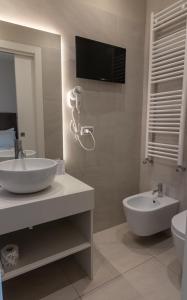 a bathroom with a sink and a toilet and a television at Gatto Bianco Le Terrazze in Bari +25 photos
