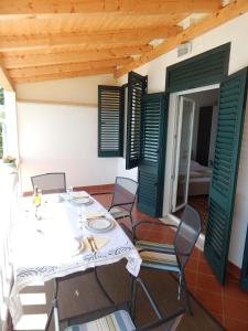 a dining room with a table and chairs and green shutters at Apartment Perica in Dubrovnik