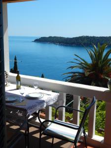 a table and chairs on a balcony with a view of the ocean at Apartment Perica in Dubrovnik +42 photos