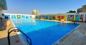 a large pool with blue water in a building at Eilat Octopus Apartment - אילת אוקטופוס -שני חדרים וסלון, בריכה בקיץ in Eilat