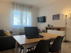 a laptop sitting on a wooden table in a living room at Sabo Urban Stay in Grassobbio