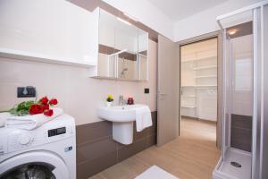 a bathroom with a sink and a washing machine at Villa Inti in Tremezzo +43 photos