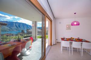 a dining room with a table and a view of the mountains at Villa Inti in Tremezzo