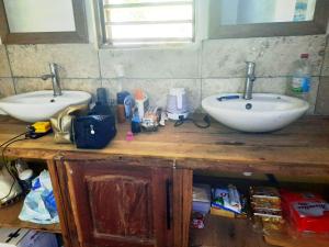 a bathroom with two sinks on a wooden counter at Chez Rosa in Nosy Be +4 photos