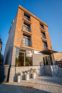 a tall brick building with windows and a staircase at Doors Boutique Hotel in Tbilisi City