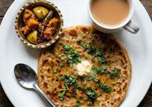 a white plate with a plate of food and a cup of coffee at Hotel Meerut International in Meerut +24 photos
