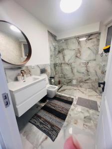 a bathroom with a sink and a toilet and a mirror at Apartamente CASA MIRIAM in Lugoj +55 photos