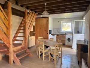 a kitchen and dining room with a table and stairs at Le gîte de la courte soupe in Éteignières
